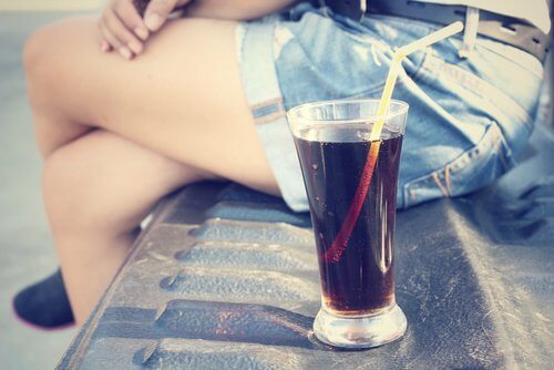 Woman's legs and glass of cola
