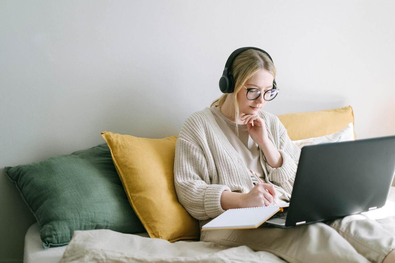 A woman sitting in her home working on her laptop.