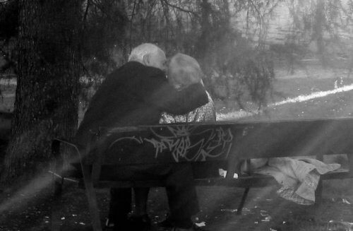 An elderly couple sitting in the park.