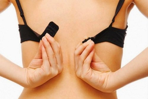 woman putting on bra