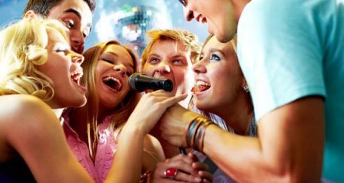 A group of people singing into a microphone.