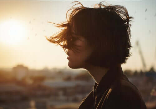 A woman with her hair in her face from the wind.