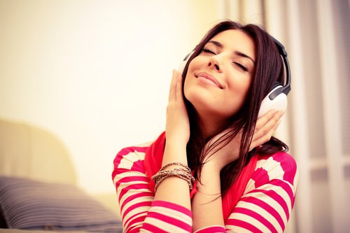 Smilende kvinde lytter til musik