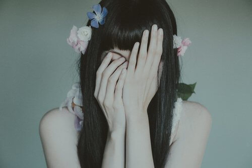 Sad girl covering her face