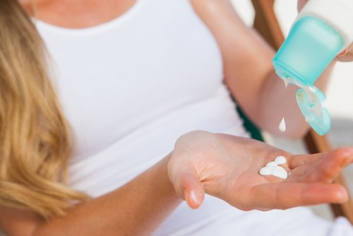 A woman applying sunscreen.