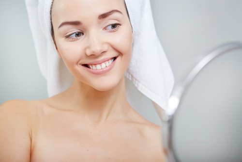 A woman smiling in the mirror.