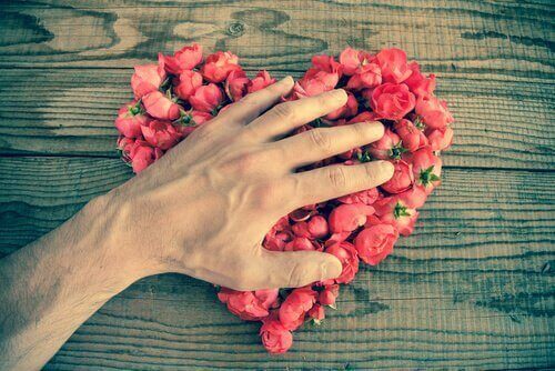 Hand on a heart of roses