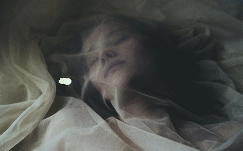 Crying girl with a sheer fabric on top of her face