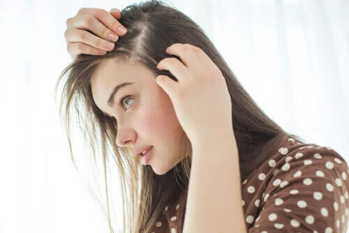 A young woman looking for grey hairs.
