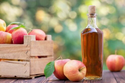 A box of apples and a bottle of vinegar.