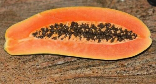 A papaya on a stone table.