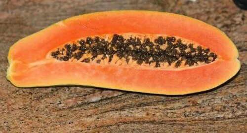 A papaya on a stone table.