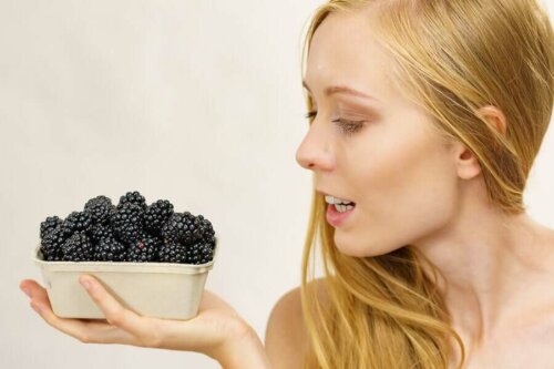 A woman holding a basket of blackberries.