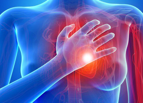 Someone touching their heart to indicate they suffer from hypertension