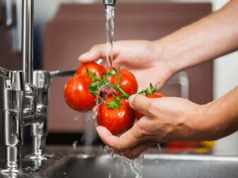 Cleaning tomatoes under faucet