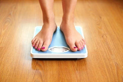 Woman standing on scale helps lose weight benefits of eating oats
