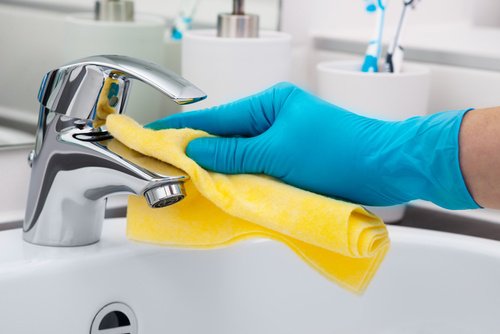 Person cleaning a faucet