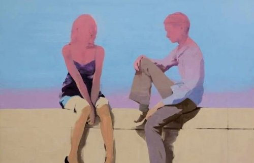 A couple talking sitting on a wall