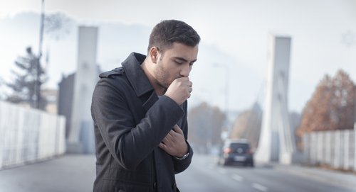 Man coughing on the street in winter remedies for a cough