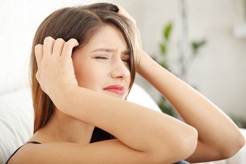 Woman holding head headaches need to detox