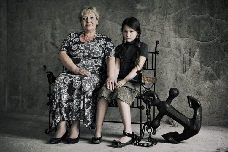 A sad girl chained to her mother