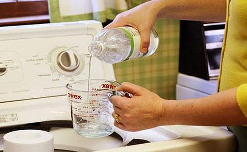 Woman pouring vinegar into a cup