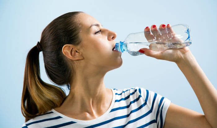 A woman drinking water.