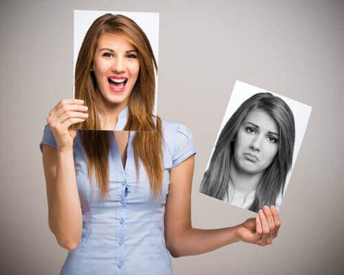 woman holding a picture of a sad and happy face
