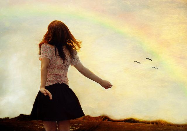 A woman looking at a rainbow.