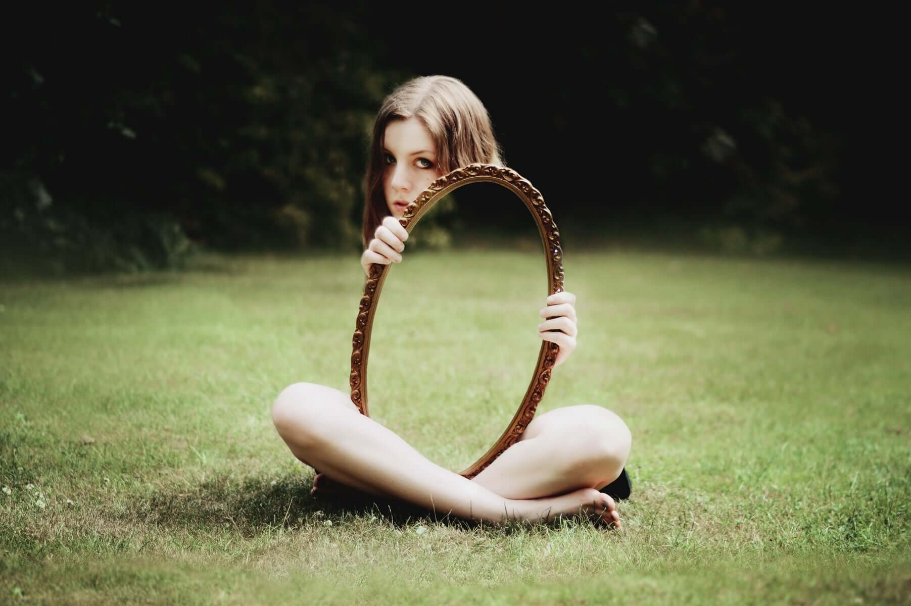 Law of mirrors; a woman holds a mirror outside.