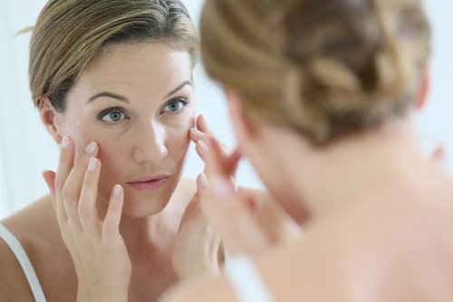 Woman looking in the mirror for aging signs