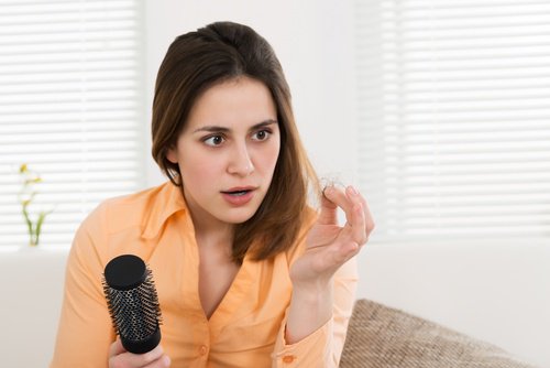 Woman holding a ball of hair that fell out