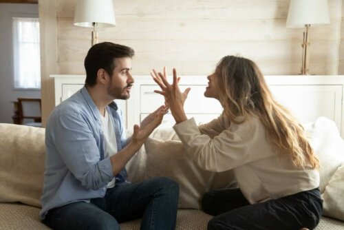 heterosexual couple arguing sat on a sofa