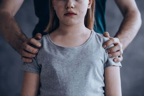 A girl crying and being held by her father.