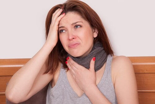 Woman in pain grasping throat with scarf on