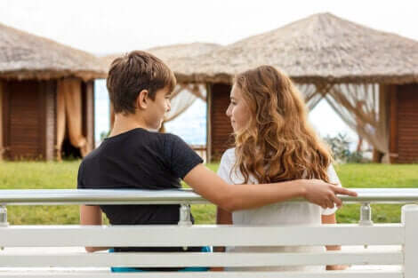 A teen couple on a bench.