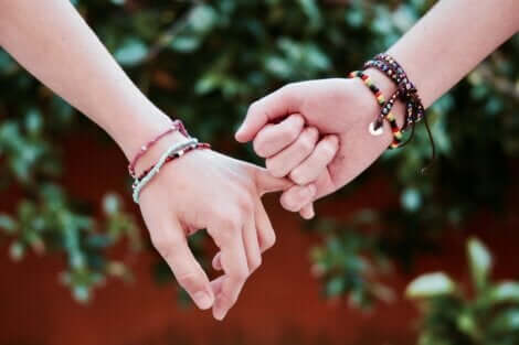 A teen couple holding hands.