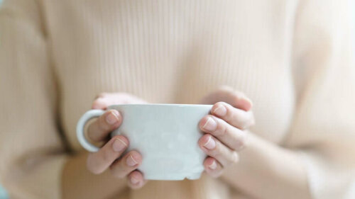 A woman holding a cup of tea.