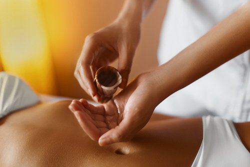 Someone pouring essential massaging oils in their hands