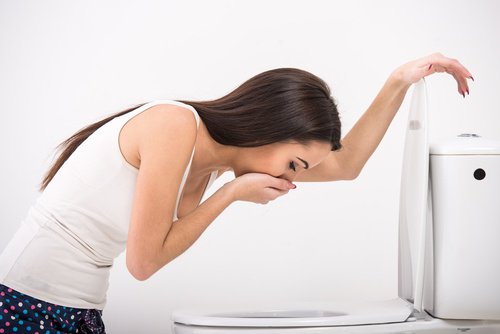 Girl being sick in the toilet.