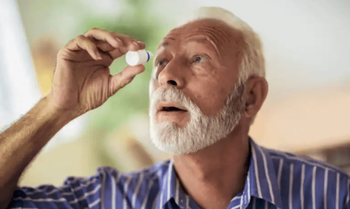 A man using eye drops.