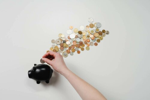 A person solving some riddles by putting coins in a piggy bank.