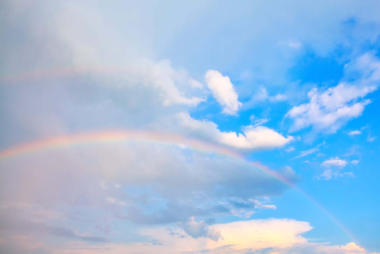 A sunny sky and a rainbow.