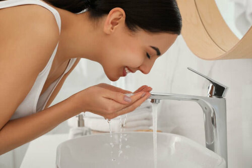 A woman washing her face.