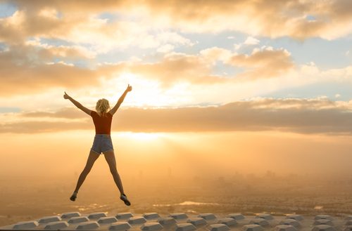 woman with energy doing a star jump