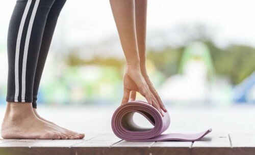 A woman rolling her mat.
