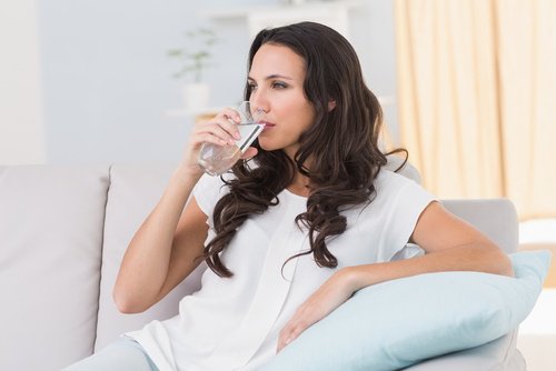 woman drinking water to help with bleeding hemorrhoids