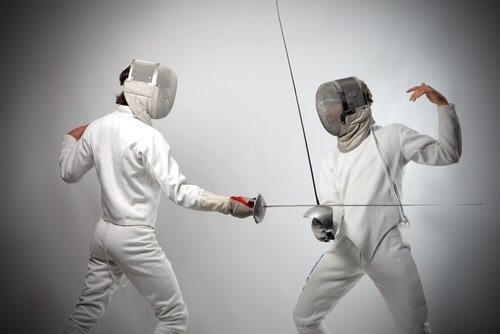 Two people playing fencing.