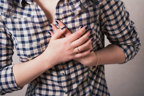 A woman clutching her chest in pain.