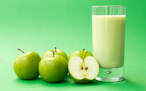 A glass of milk and some apples
